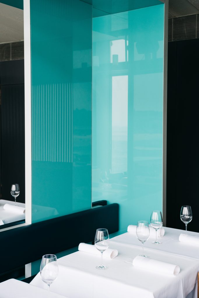 Icebergs interior corner with teal tones and set tables