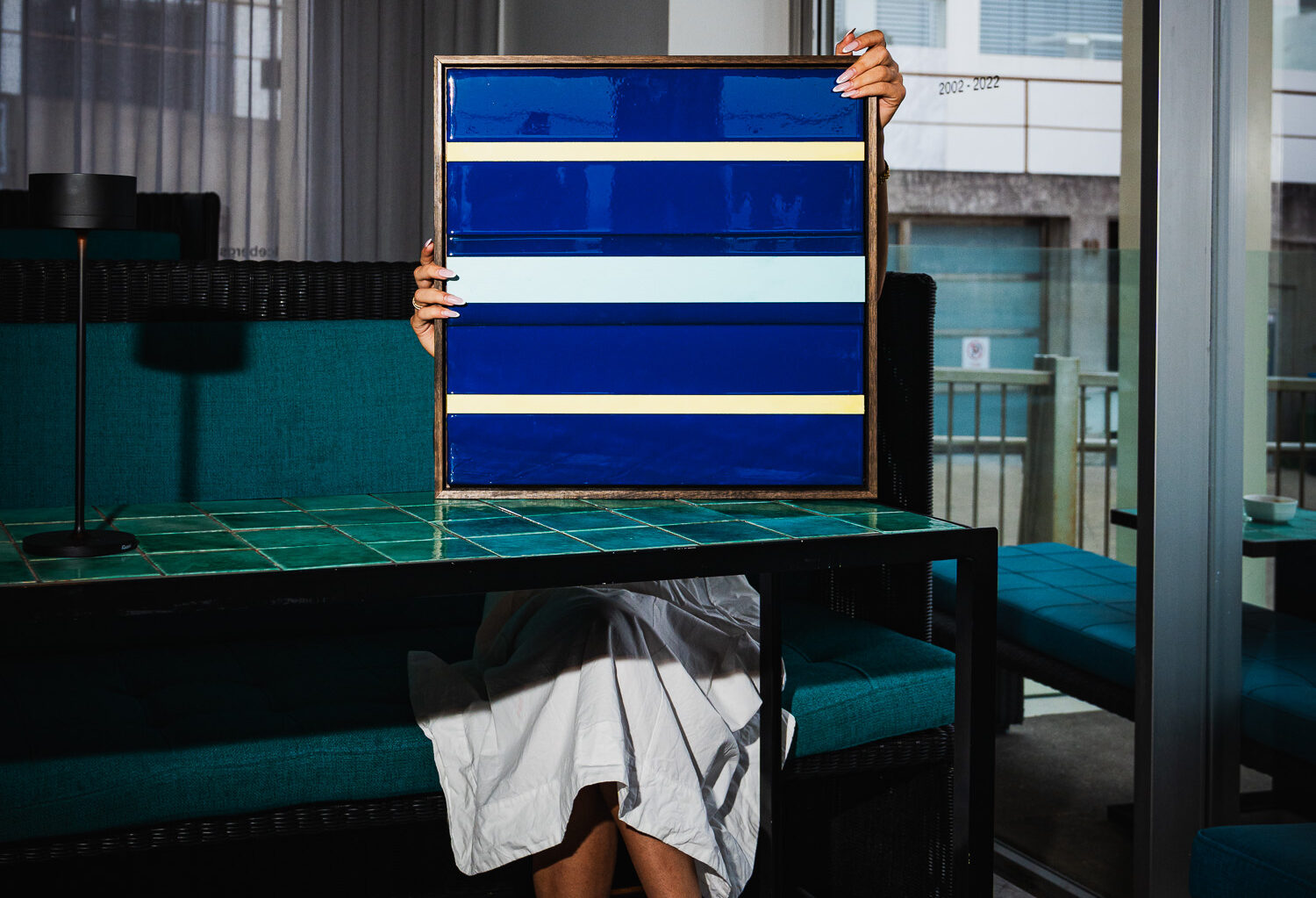 Person holding the blue-striped Full Moon print by the pool
