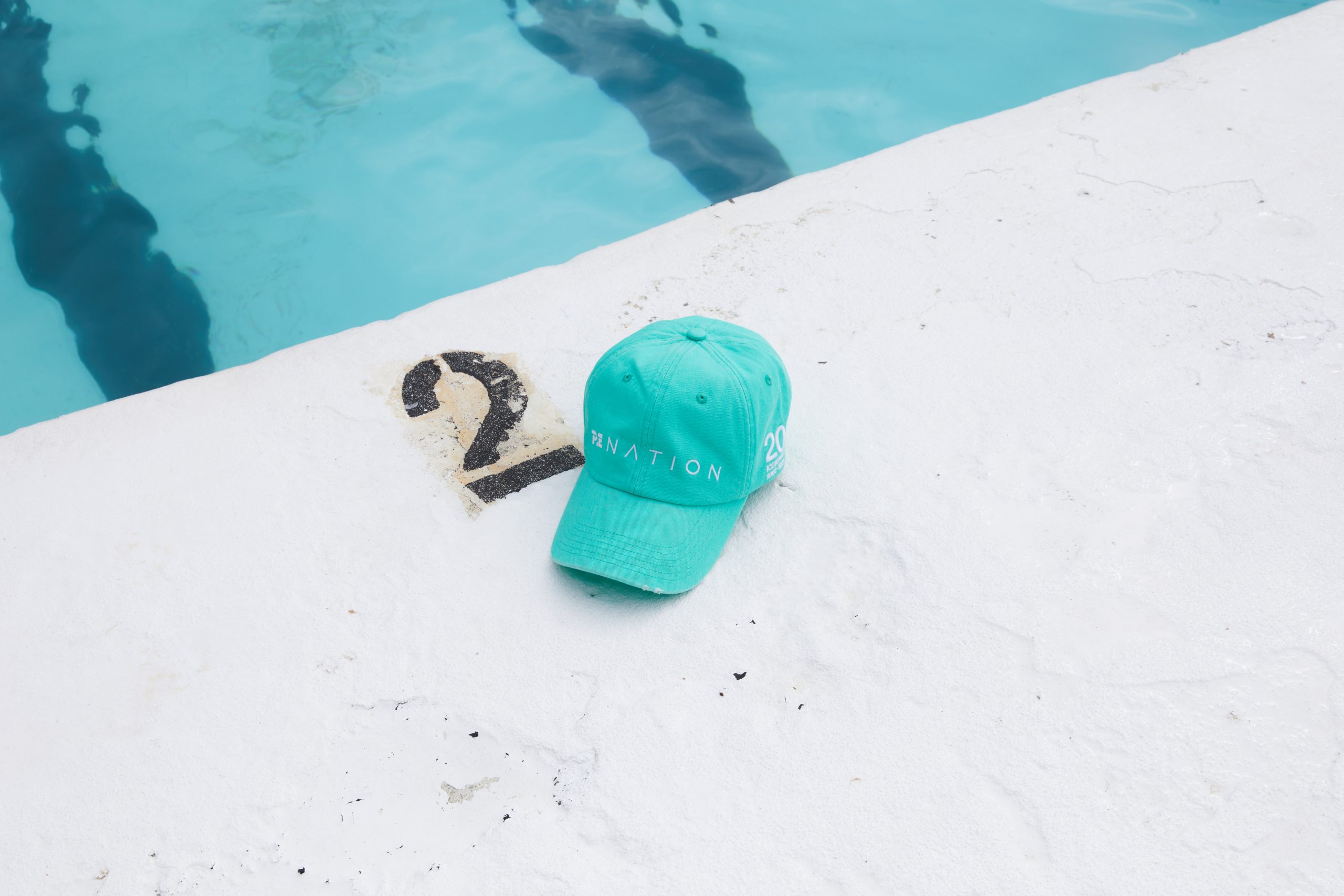 Teal Icebergs cap on the pool edge with a number 2