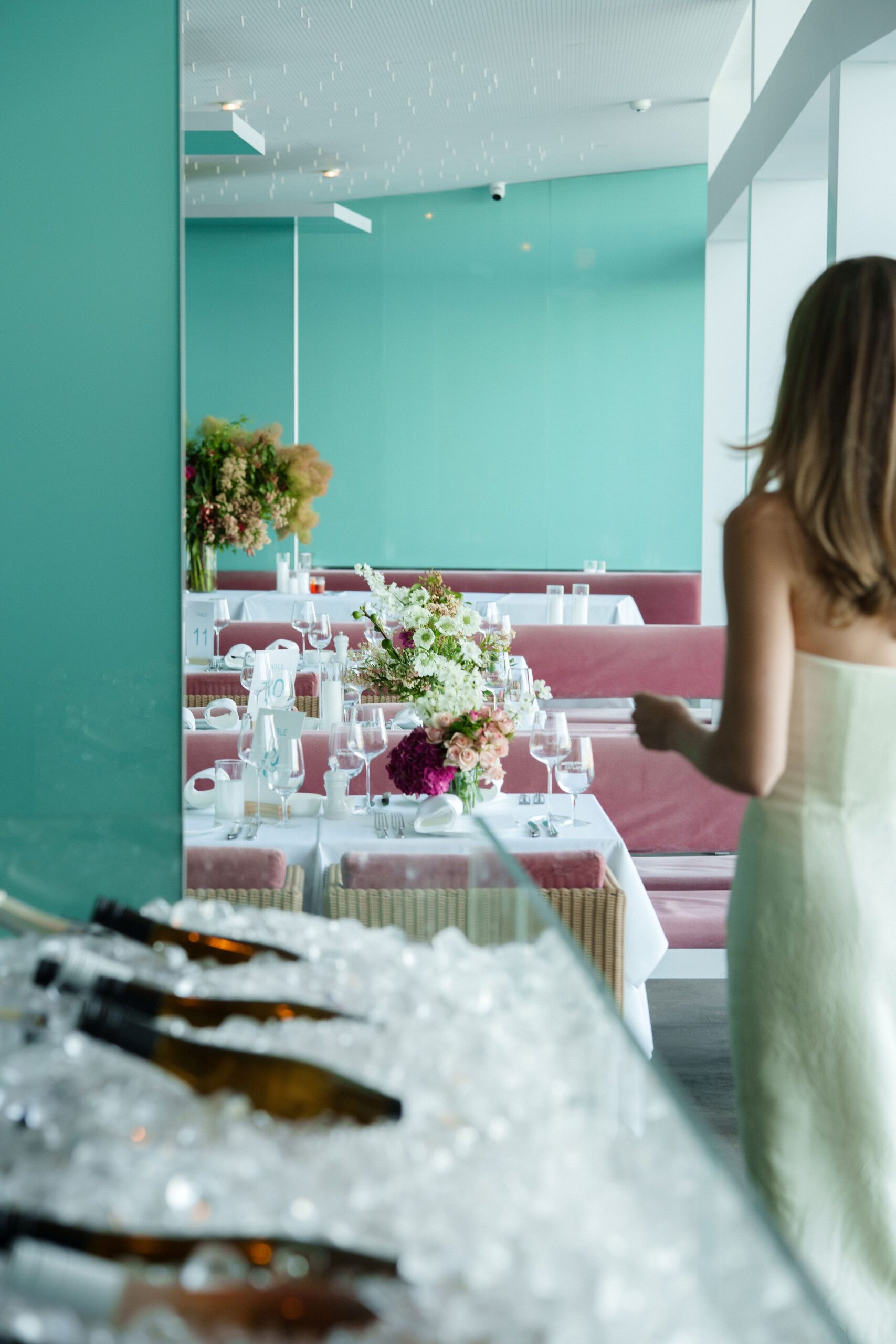 Guest walking past a long event table set beside a seafood display on ice