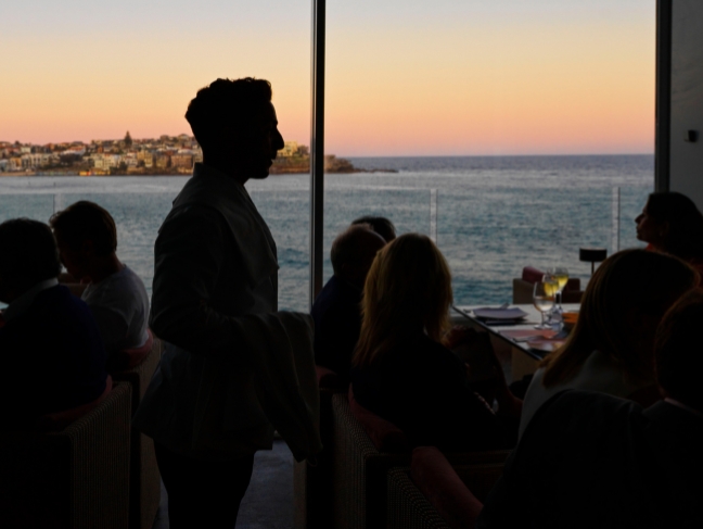 Diners silhouetted against the sunset over Bondi