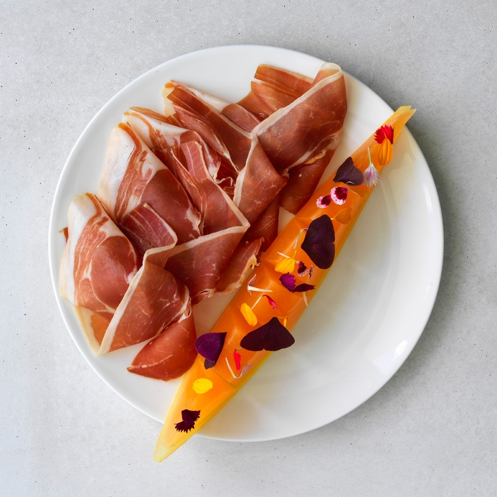 Prosciutto and melon on a white plate