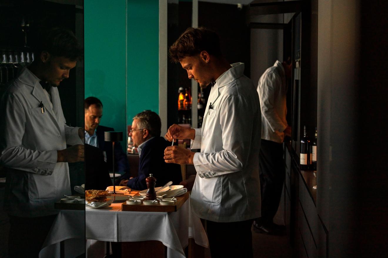 Icebergs waiters serving guests at a dining room table