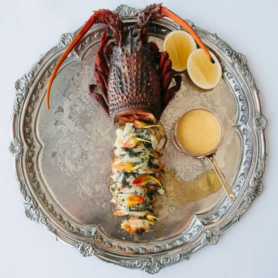 Lobster served on a silver platter with two sauces